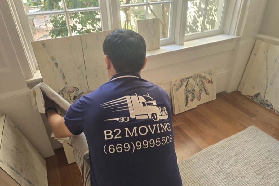 Mover carefully packing framed art